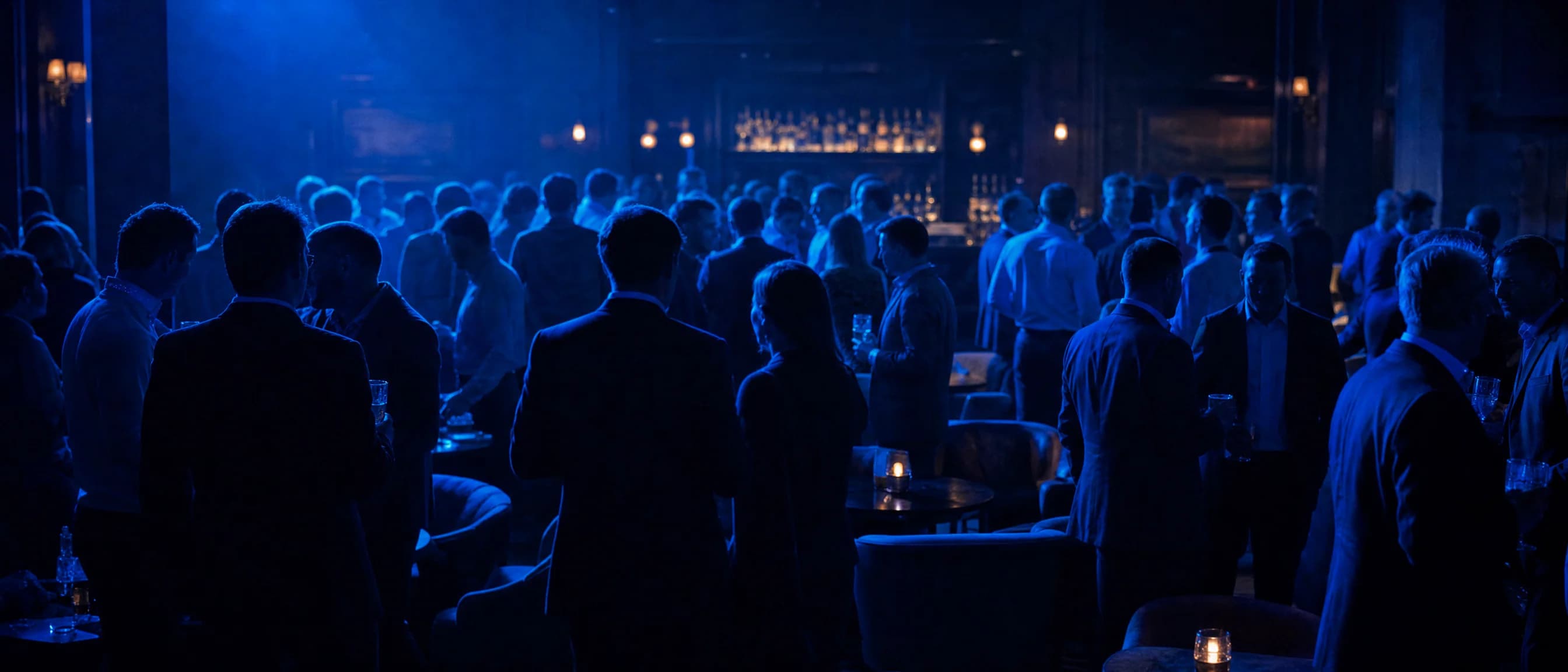 A club night: a full bar in blue light, people in conversation